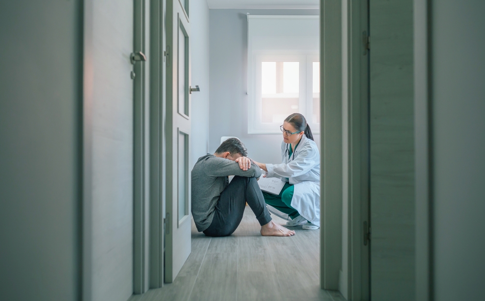 Psychiatrist sitting beside a distressed patient on the floor during a personality disorder evaluation